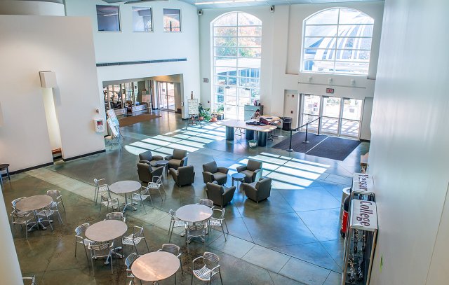 A bright interior space with round tables and large windows