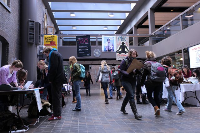 Many students walking through a building interior