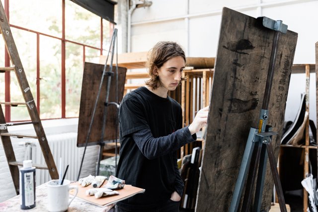 A student drawing on an easel