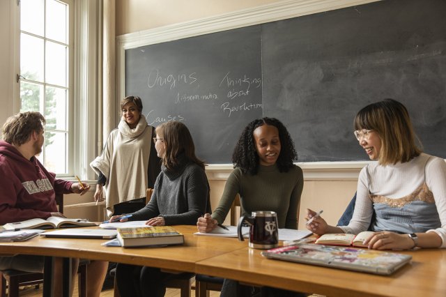 Four students and a professor in a classroom