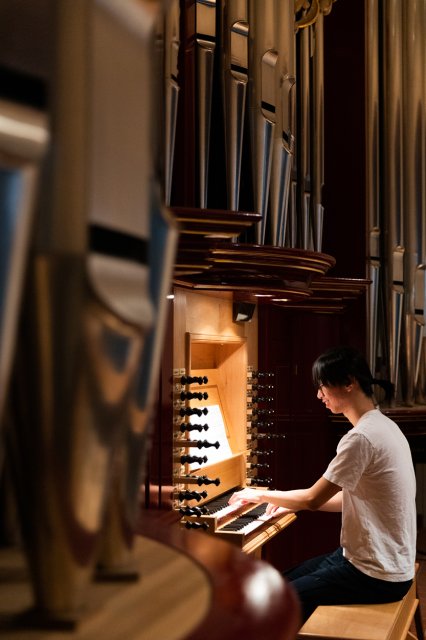 A student playing a pipe organ