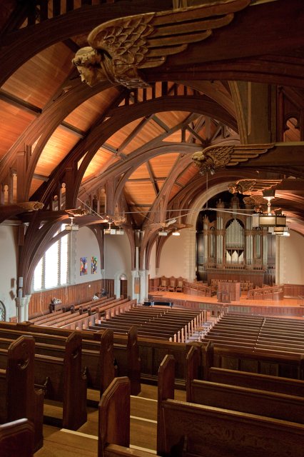 Interior of the chapel with pews and carved wooden features