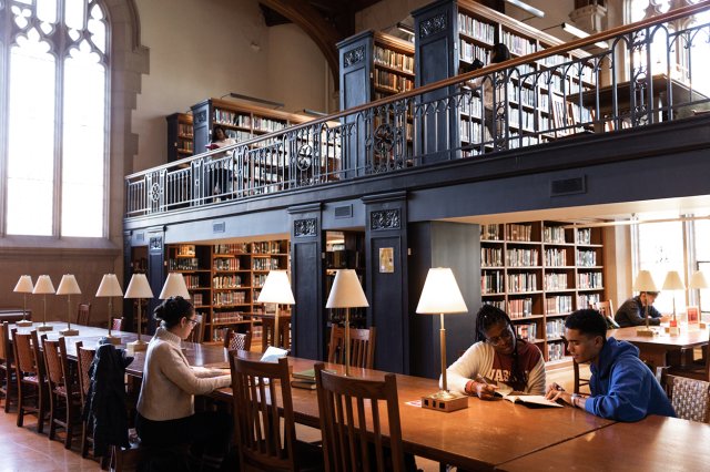 Students sitting at a large table, reading