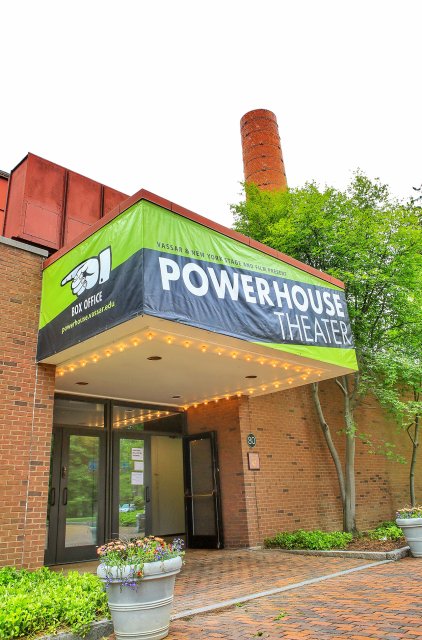 The exterior of a building with a large bannner reading "Powerhouse Theater"