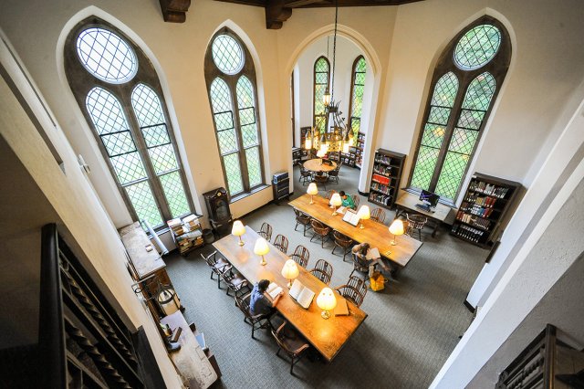 A room with large windows and long tables, viewed from above